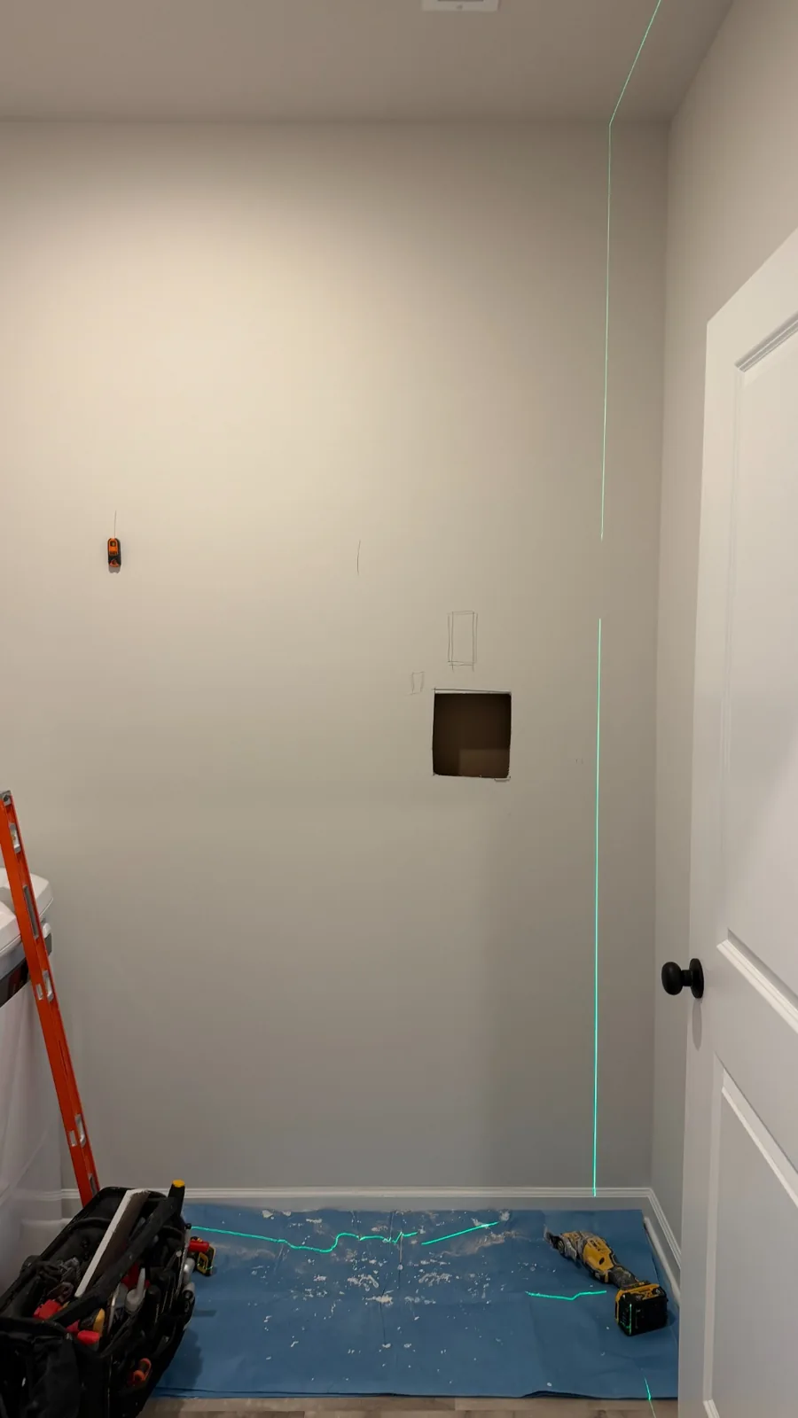Closet wall marked for a new doorway with a small inspection opening