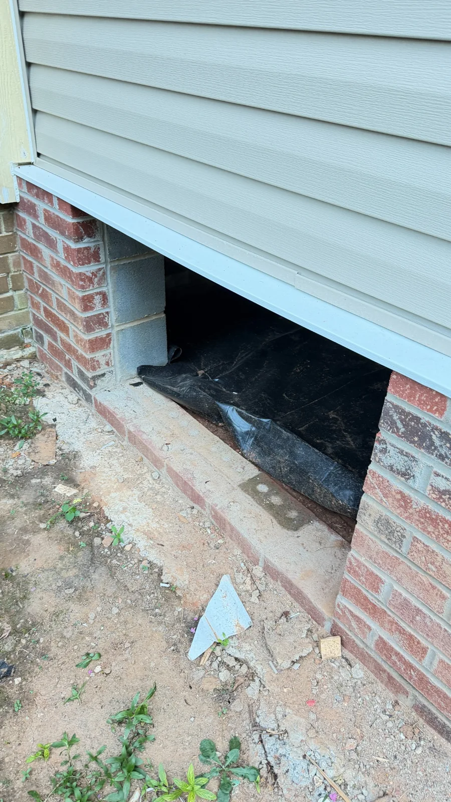 Open crawl space entrance in a brick foundation