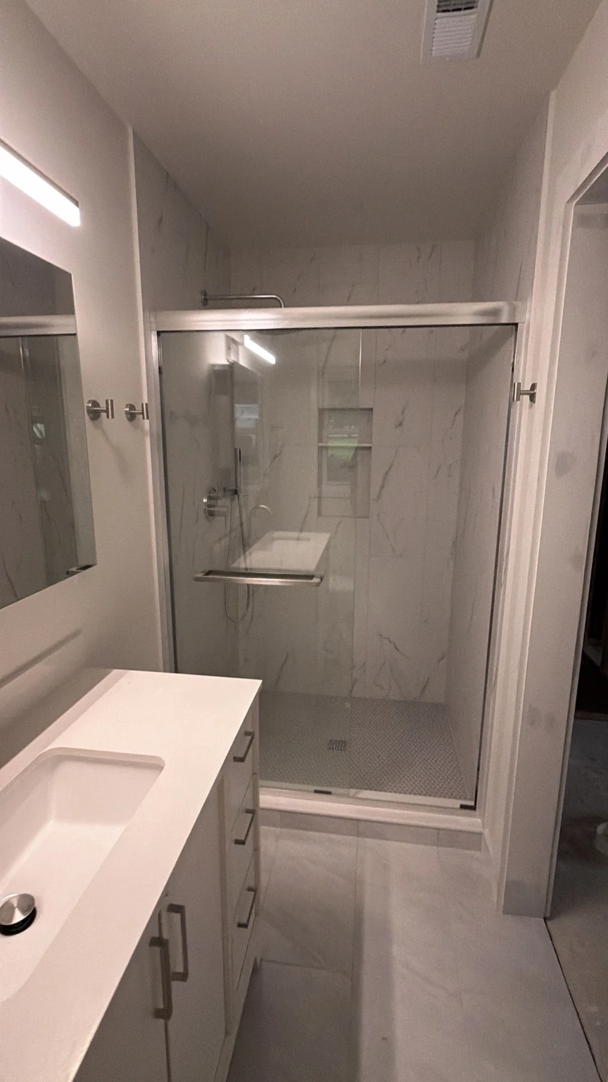 Completed bathroom with a glass-enclosed shower and updated vanity