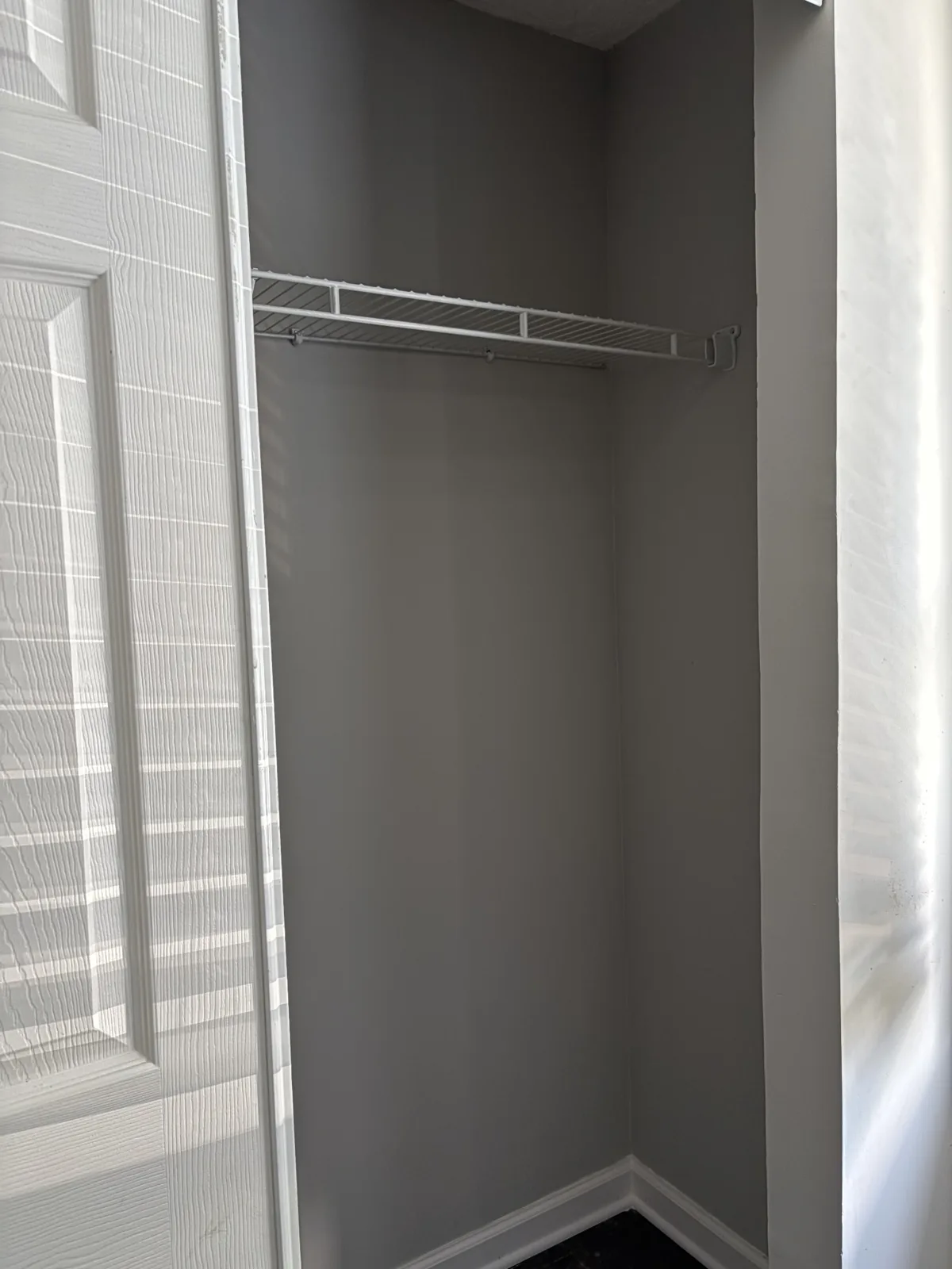 Restored closet wall with gray paint, white trim and wire shelving
